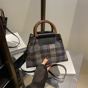 Retro plaid wool handbag with brown round handles and black leather crossbody strap