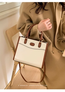 Detailopname van minimalistische retro draagtas met dubbele handvatten en kleurcontrast