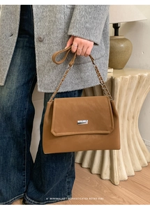Detail of retro brown crossbody bag with silver buckle and chain leather strap