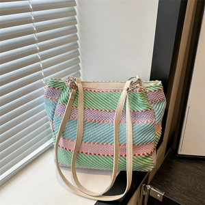 Sac fourre-tout tissé à rayures colorées avec bandoulière en cuir crème sur un rebord