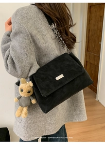 Large black chain tote bag featuring a cute bunny plush charm on a shoulder strap