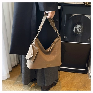 Détail du sac hobo en cuir kaki avec garnitures dorées et son petit porte-monnaie assorti