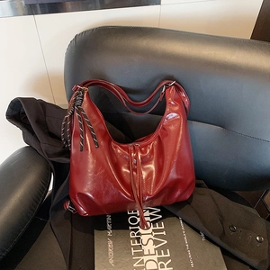 Retro wine red tote bag with glossy wrinkled texture and braided rope detail shown on chair