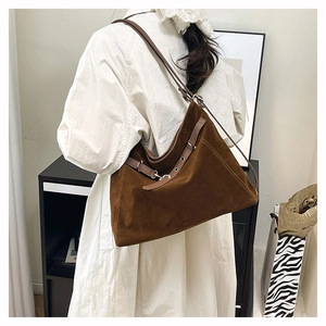Dettaglio della grande borsa tote in pelle scamosciata marrone scuro con fibbia in metallo