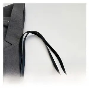 Détail du sac cabas matelassé beige avec poignées en cuir noir fines et coutures renforcées
