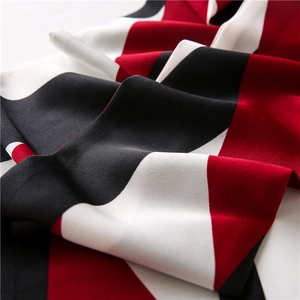 Macro detail of wine red geometric patchwork silk scarf with smooth satin texture