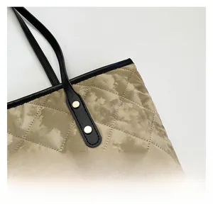 Détail d'un sac cabas matelassé avec tissu à motif marbré et rivets de poignée en cuir