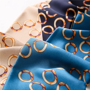 Close-up of silk scarf fabric showing satin texture and geometric ring patterns