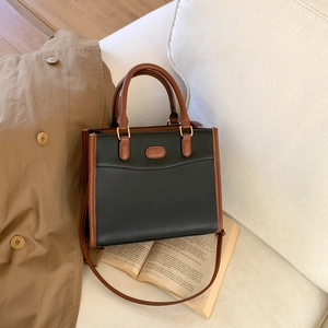 Retro two-tone patchwork tote bag in black and brown on a white sofa with cozy decor