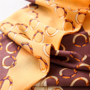 Macro view of silky orange and coffee scarf with interlocking rope ring pattern