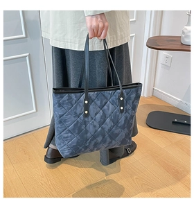 Détail du sac cabas matelassé camouflage avec anses en cuir noir et rivets dorés
