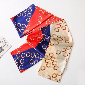 Detail view of the silky long scarf featuring color-block patterns and golden ring prints