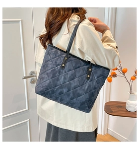 Détail d'un grand sac cabas matelassé camouflage avec coutures en losanges et cuir noir