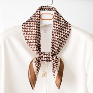 Close-up of a vintage geometric print silk scarf tied as a necktie on a white shirt