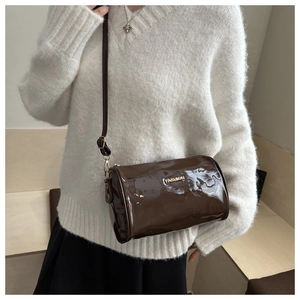 Mannequin portant un sac Boston matelassé marron foncé avec plaque dorée