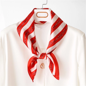 Détail d'un foulard en soie rayé rouge et blanc avec motif chaîne sur une chemise