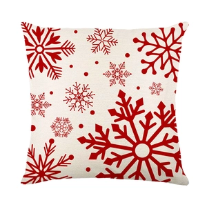 Red snowflake Christmas pillow cover on beige fabric for festive sofa decoration