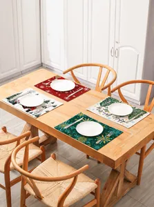 Macro view of four festive Christmas cotton linen placemats with holiday prints on wood table