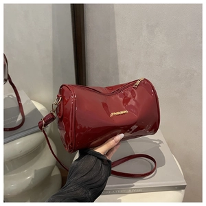 Détail macro du sac Boston en cuir verni rouge avec lettrage FASHION doré et zip métallique