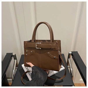 Vue détaillée du sac rétro marron foncé avec boucle décorative et rivets en métal