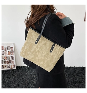 Vue détaillée du sac cabas matelassé beige montrant sa capacité et ses anses noires