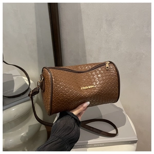 Détail du sac tonneau tressé marron foncé avec logo doré et fermeture éclair