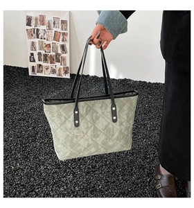 Détail d'un sac cabas matelassé avec motif marbre vert clair et anses en cuir noir