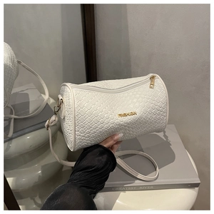 Détail du sac cylindrique blanc à texture tressée et logo Fashion en métal doré