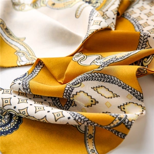 Détail d'un foulard en soie avec motif de chaîne baroque jaune gingembre et imprimé