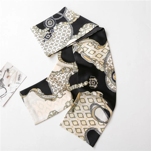 Vue détaillée du foulard étroit satiné aux motifs de chaînes dorées sur fond noir chic