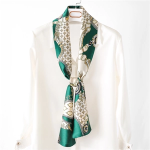 Écharpe rétro en soie vert émeraude à motif géométrique sur une chemise blanche