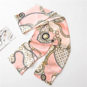 Détail d'un élégant foulard en soie rose avec chaînes dorées et motifs bijoux vintage