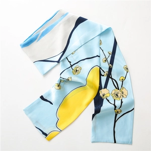 Détail d'une écharpe bleu clair avec fleurs de prunier et motifs géométriques
