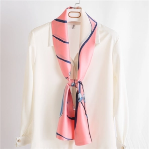 Foulard élégant en soie rose à motif floral et rayures bleues sur une chemise blanche