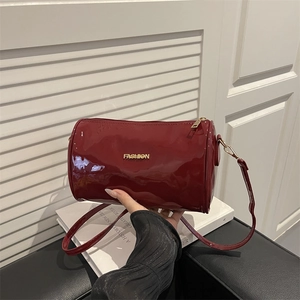 Sac Boston cylindrique en cuir verni bordeaux matelassé avec des détails dorés chic