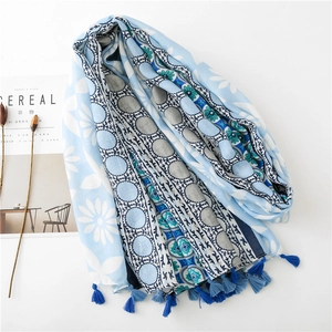 Three-color floral cotton linen scarf with tassels and geometric print displayed on a table