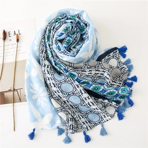 Bohemian light blue floral scarf with geometric patterns and tassels on white background