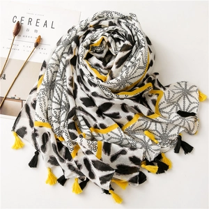 Detail of soft cotton scarf with black polka dots, yellow stripes and fringe tassels