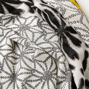 Detailed close-up of lightweight black and white polka dot scarf fabric texture