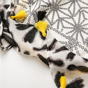 Detail of floral dot patterns and vibrant yellow fringe tassels on this summer shawl