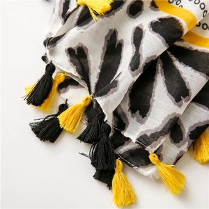Detailed close-up of leopard abstract print scarf with two-tone fringe tassel edges