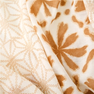 Close-up of soft linen-touch scarf featuring beige fabric with caramel floral patterns