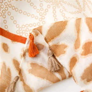 Detailed close-up of patterned scarf with leopard print dots and soft tassel fringes
