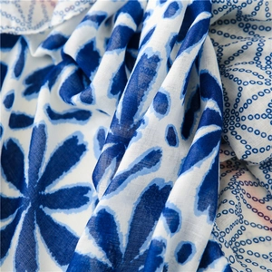 Macro detail of breathable blue and white floral print fabric with a soft woven texture