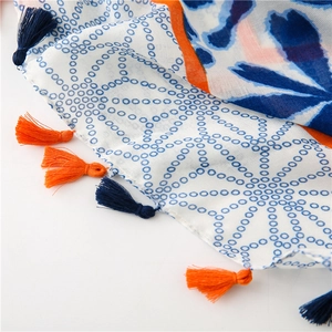 Close-up of geometric floral pattern and handmade tassels on cotton linen scarf