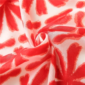 Macro view of light red and white floral cotton scarf showing semi-transparent texture