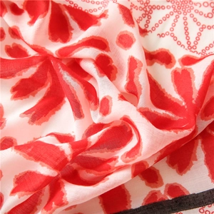 Macro detail of red floral print scarf showing lightweight linen texture and fine black hem