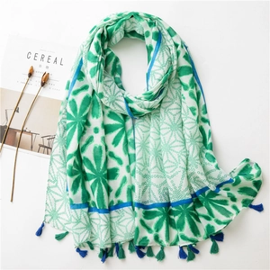 Close-up of lightweight floral scarf with green dots and navy blue tassel edges
