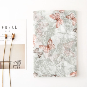 Cotton linen floral scarf with orange butterflies and magazine prop in minimalist setting