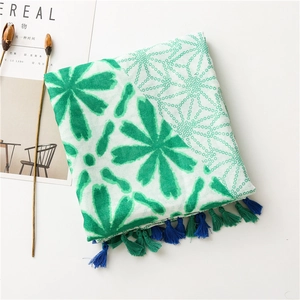 Detail of floral and polka dot pattern scarf with delicate green and blue fringes